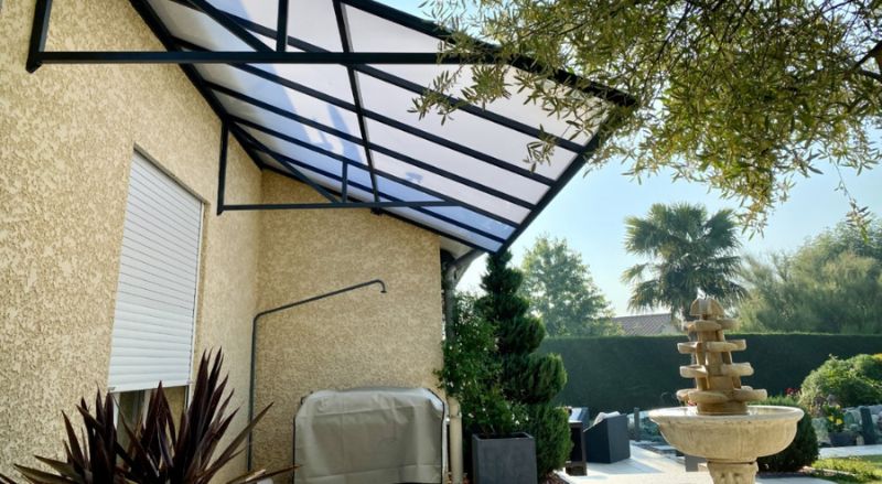 auvent en polycarbonate et aluminium adosse au mur d une terrasse