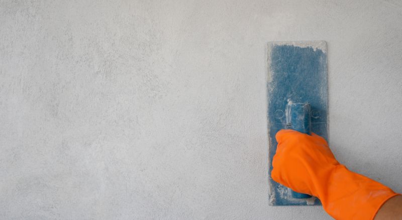 main d ouvrier lissant un mur parfaitement droit et renove