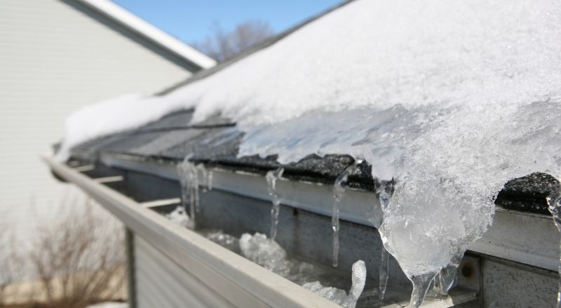 neige et glace sur le toit d'une maison